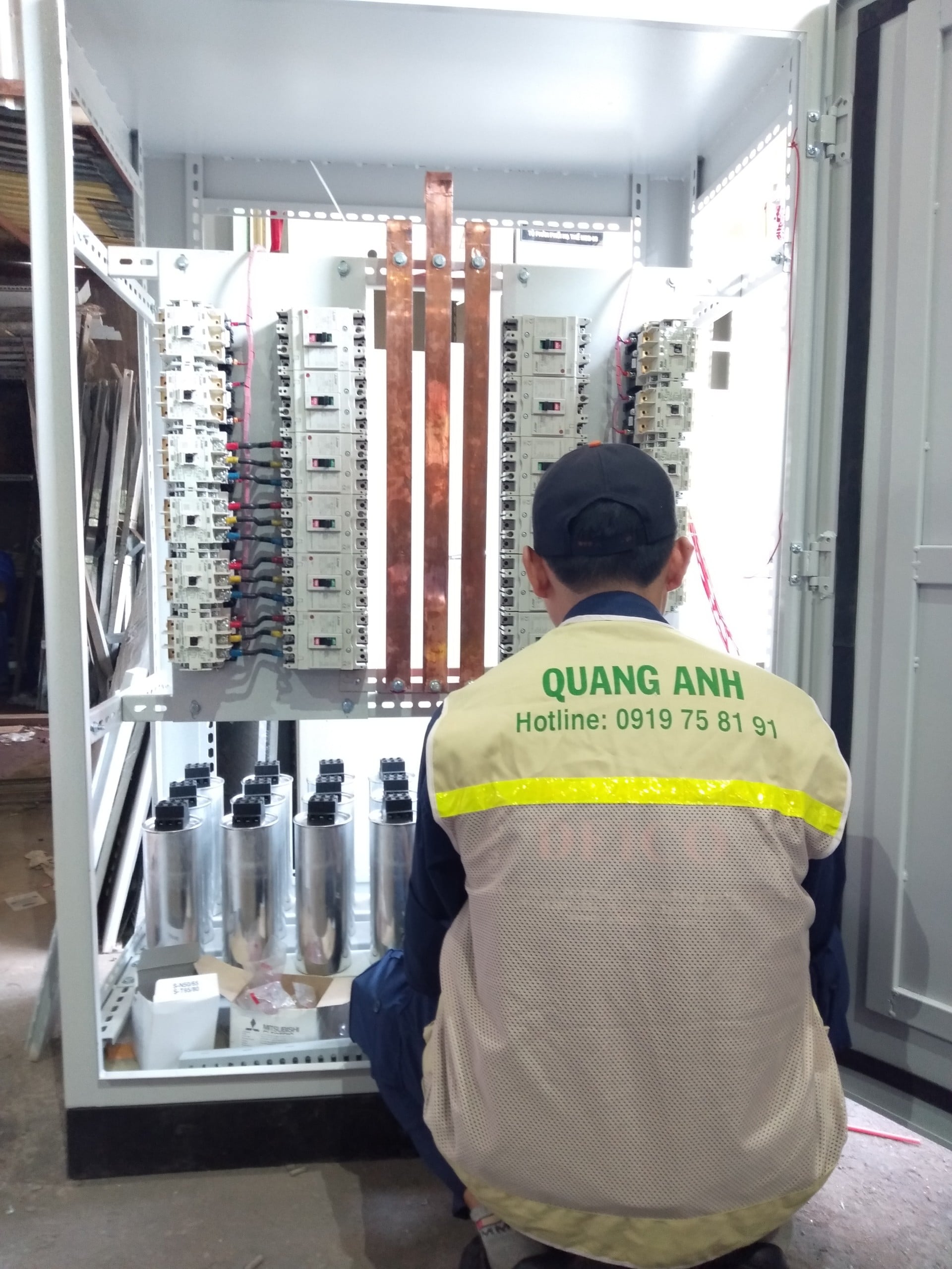Kỹ thuật viên kiểm tra đấu nối trong tủ điện có thanh cái và CB