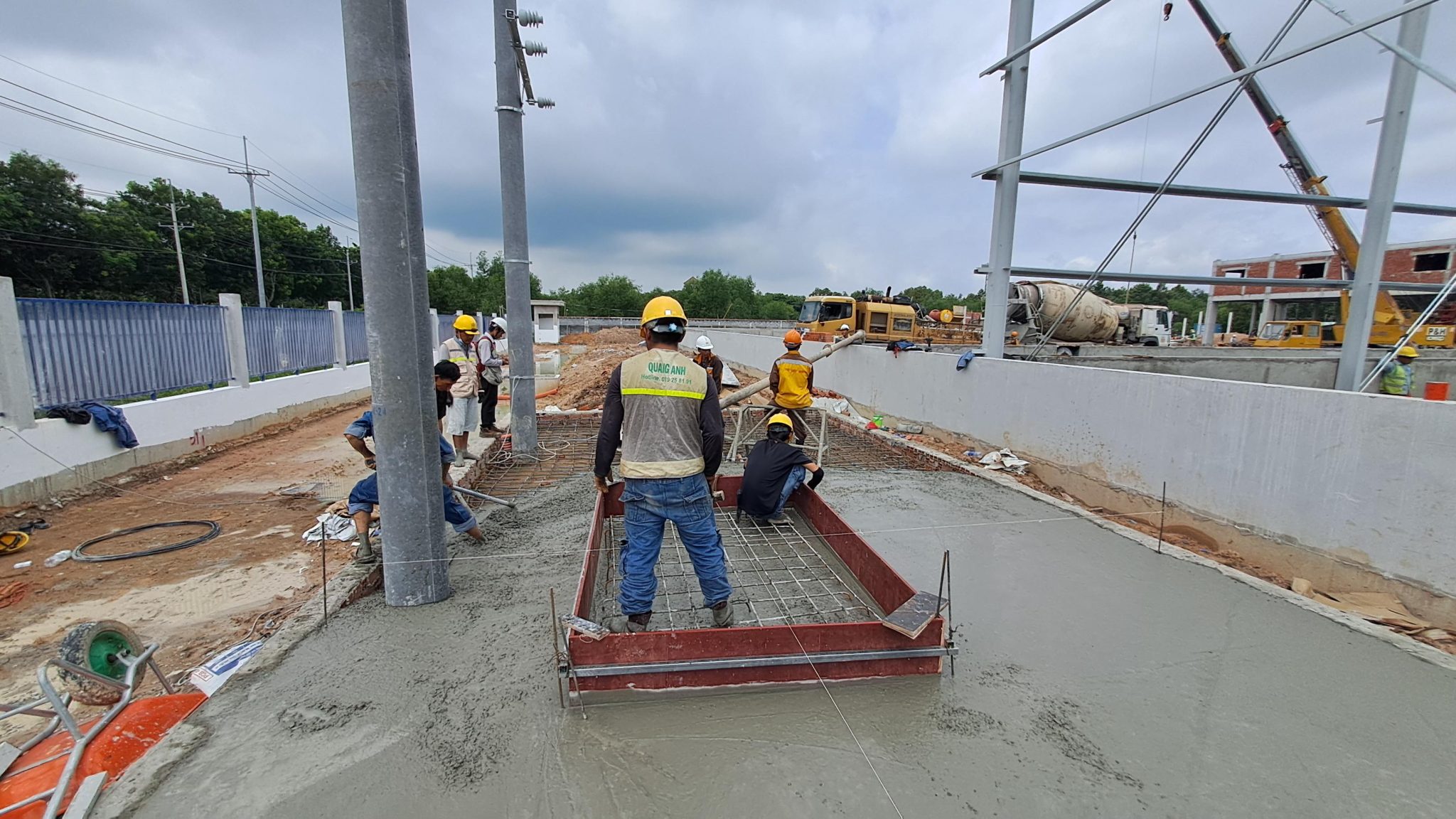 Kỹ thuật viên đang lắp đặt thang máng cáp trong môi trường công nghiệp.